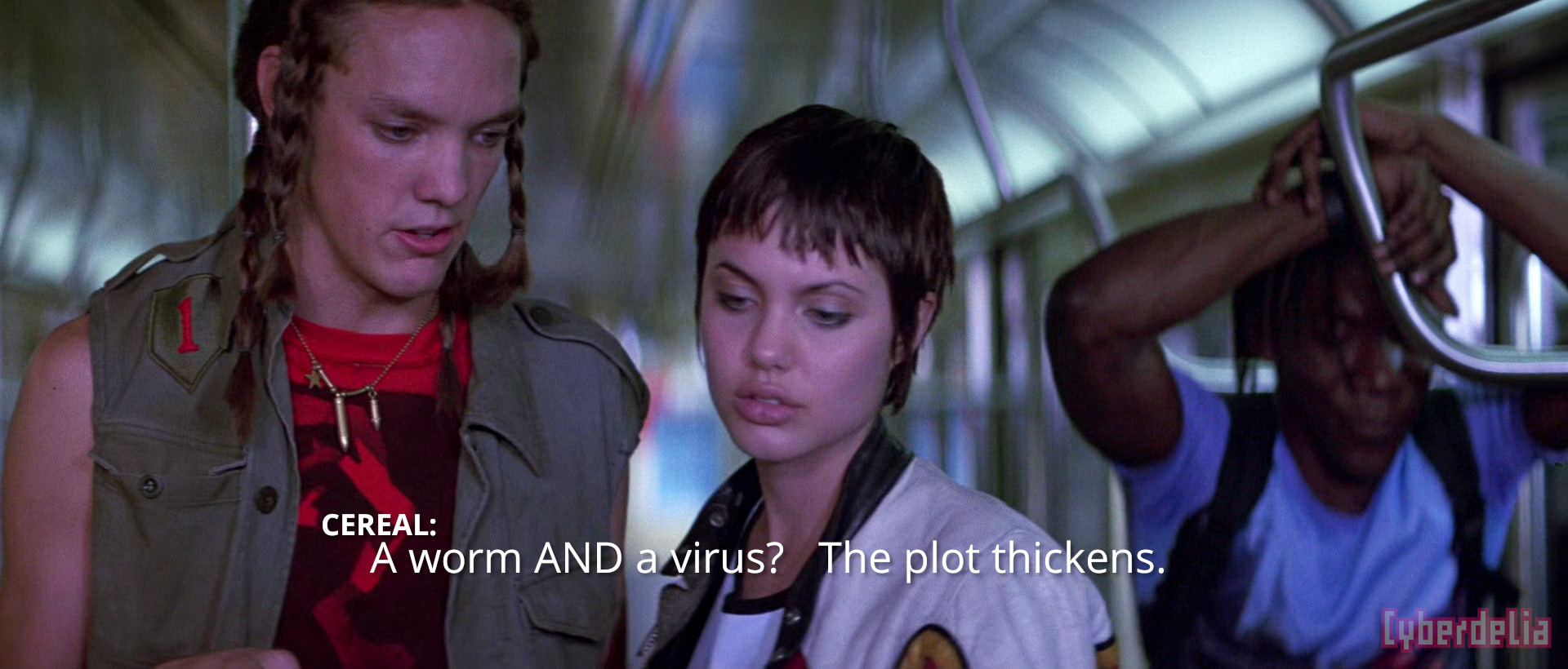 Scene from Hackers (1995) film with the characters Cereal Killer, Acid Burn and Lord Nikon on a subway car holding a piece of computer paper intently as they discuss and realize a key detail of a heinous scheme framing their friends (Lord Nikon leans against subway door area head in hands in anger/dismay). Cereal exclaims 'A worm AND a virus? The plot thickens.'