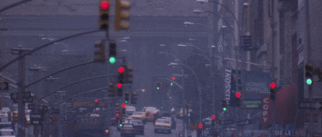 Animated GIF of scenes from Hackers (1995), traffic lights on sequential streets in New York City change from red to green  for a number of blocks into distance, Dade Murphy (Crash Override) in motion rollerblading cries out in triumph at his successful hack. Original GIF by Boardergirl20 updated by Cyberdelia NYC 2022.