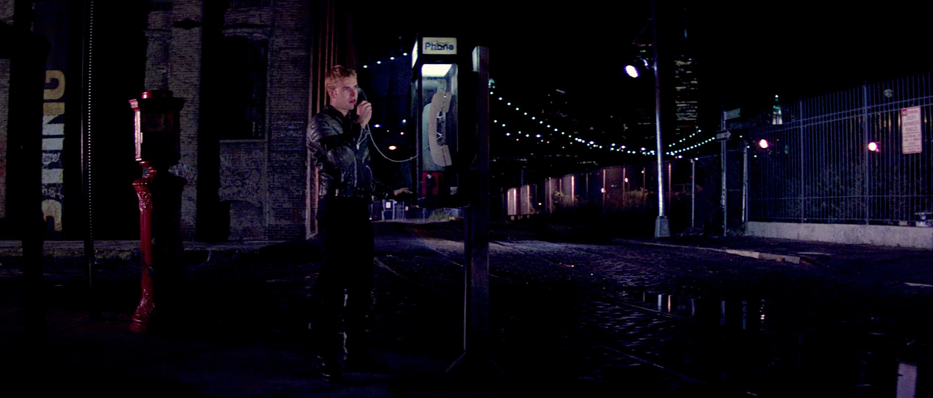 Scene from Hackers (1995) film: Dade Murphy stands on a dark, empty street in NYC on a payphone calling The Plague to arrange a handoff of a floppy disk with some coveted evidence data on it. 'Talk to me', Plague answers on the other end.