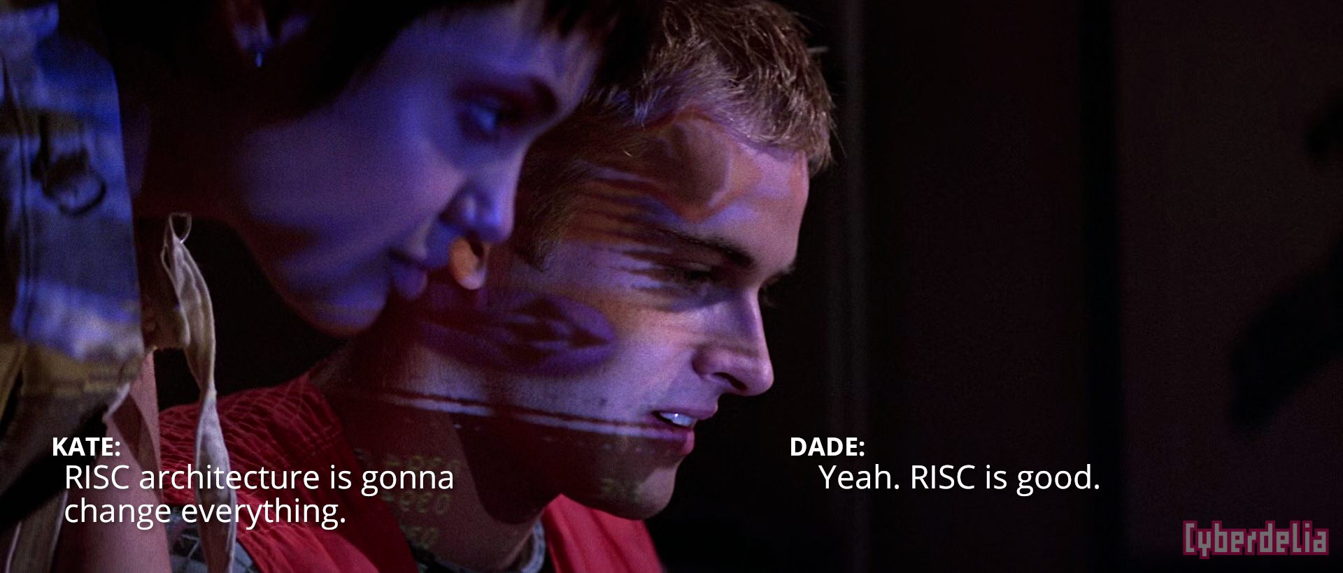 Kate: "RISC architecture is gonna change everything." Dade: "Yeah. RISC is good." Scene from Hackers (1995), characters Acid Burn and Dade Murphy played by Angelina Jolie and Jonny Lee Miller discussing technology while the glow of a laptop computer illuminates their faces.