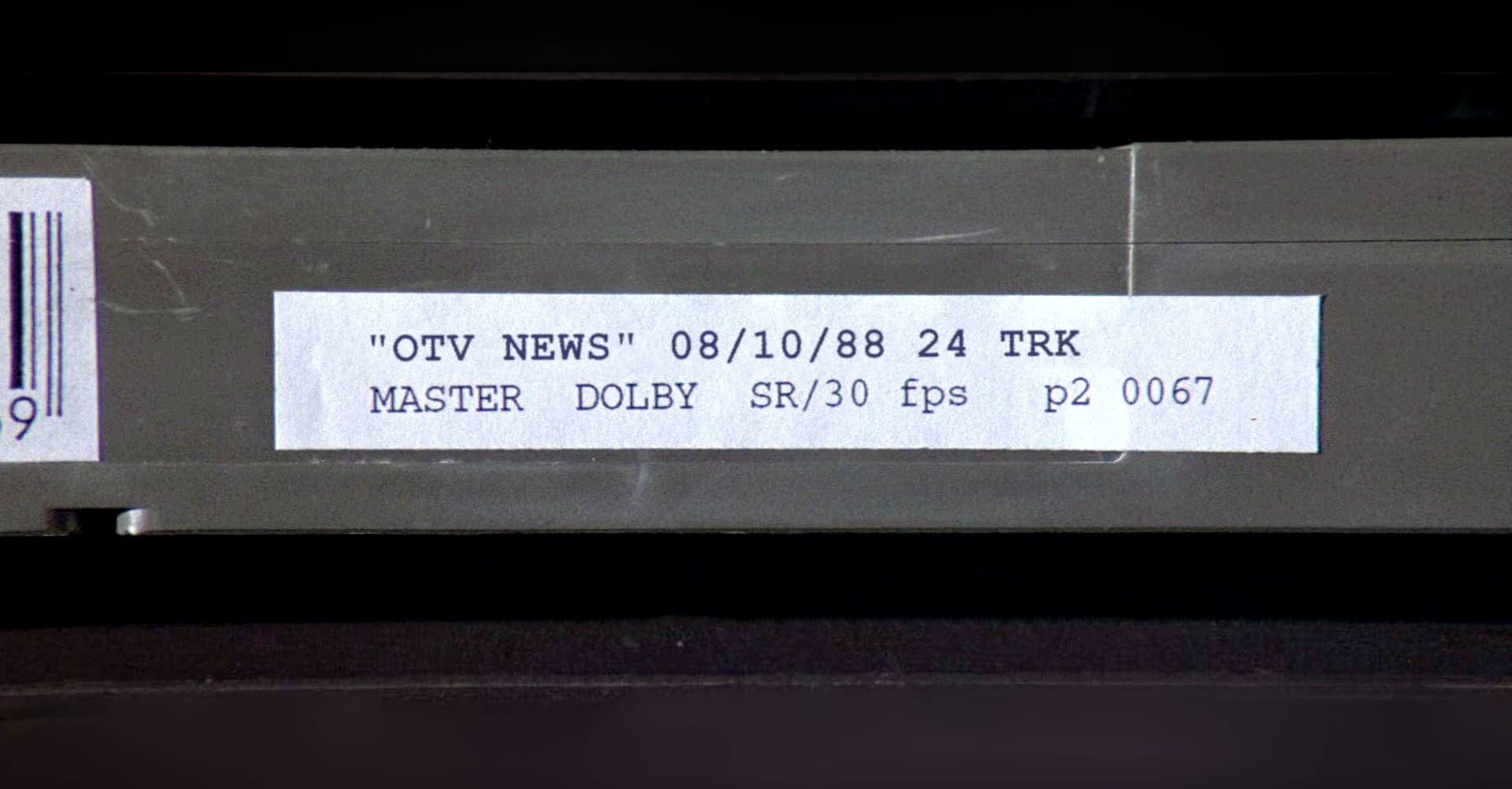 Label on a grey video cassette tape with typed text on it: 'OTV NEWS' 08/10/88 24 TRK. MASTER DOLBY SR/30 fps p2 0067.
